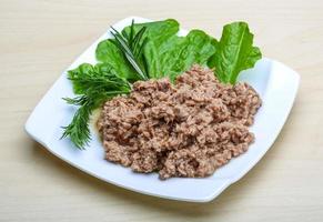 Cannded tuna on the plate and wooden background photo