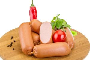 Sausages on wooden board and white background photo