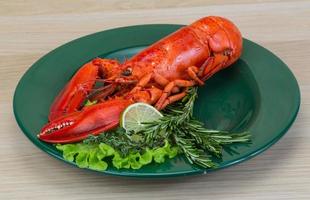 Boiled lobster on the plate and wooden background photo