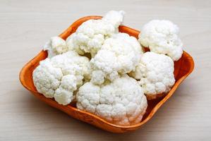 Cauliflower in a bowl on wooden background photo