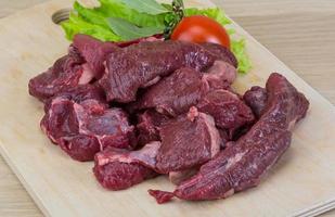 Raw venison on wooden board and wooden background photo