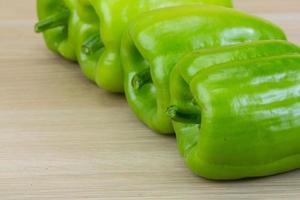 Green pepper on wooden background photo