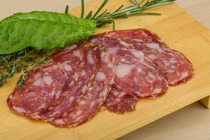 Salami on wooden board and wooden background photo