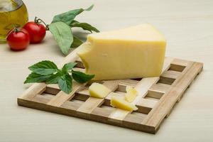 Parmesan cheese on wooden board and wooden background photo