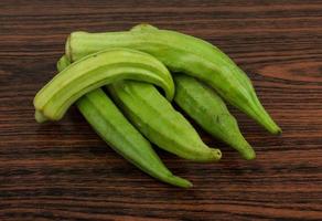 Okra vegetables on wooden background photo