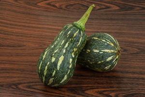 Green pumpkin on wooden background photo