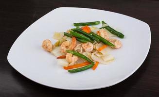 Shrimp salad on the plate and wooden background photo