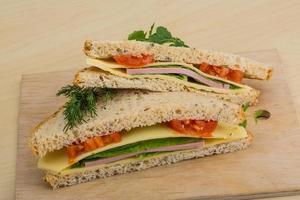 Club sandwich on wooden board and wooden background photo