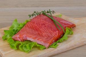 Salmon on wooden board and wooden background photo