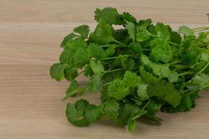 Coriander leaves on wooden background photo