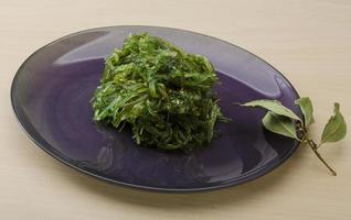 Chuka salad on the plate and wooden background photo