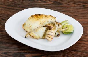 Grilled cuttlefish on the plate and wooden background photo