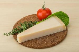 Parmesan cheese on wooden board and wooden background photo