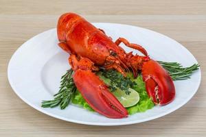 Boiled lobster on the plate and wooden background photo