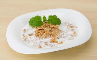 Cornflakes on the plate and wooden background photo