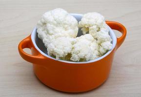 Cauliflower in a bowl on wooden background photo