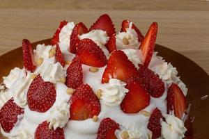 Strawberry cake on the plate and wooden background photo