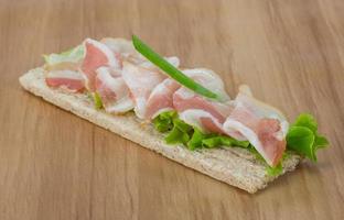 Bacon sandwich on wooden background photo