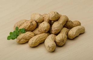 Raw peanuts on wooden background photo