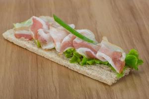 Bacon sandwich on wooden background photo