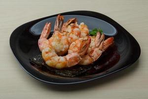 Tiger shrimps on the plate and wooden background photo