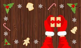 Gift and hands in red mittens on a wooden background top view, lollipops and gingerbread cookies. Concept of winter New Year and Christmas coziness. Vector stock illustration with copy space.