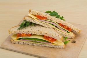 Club sandwich on wooden board and wooden background photo