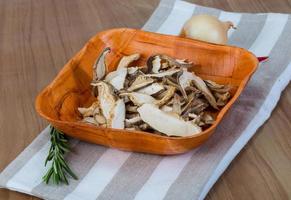 Dry shiitake in a bowl on wooden background photo