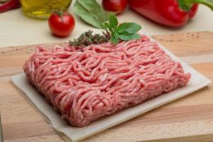 Minced meat on wooden board and wooden background photo