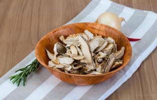 Dry shiitake in a bowl on wooden background photo