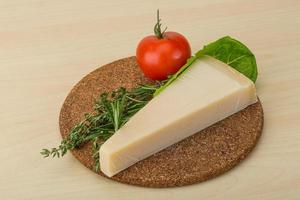Parmesan cheese on wooden board and wooden background photo