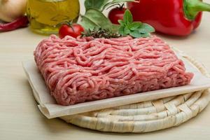 Minced meat on wooden board and wooden background photo