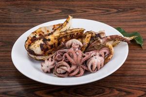 Boiled octopus on the plate and wooden background photo