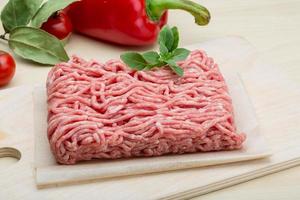 Minced meat on wooden board and wooden background photo