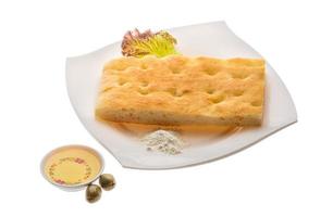 pan de oliva en el plato y fondo blanco foto