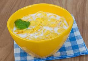 Cornflakes in a bowl on wooden background photo