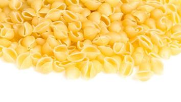 Heap of raw pasta on white background photo