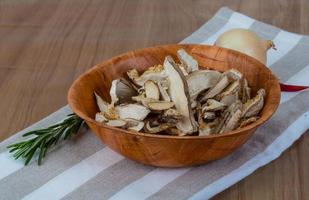 Dry shiitake in a bowl on wooden background photo