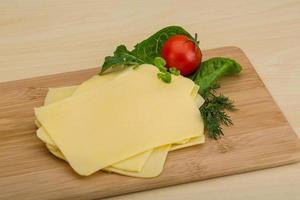 Sliced sheese on wooden board and wooden background photo