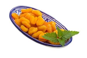 Dried apricots in a bowl on white background photo