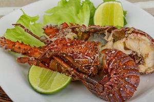 Spiny lobster on the plate and wooden background photo