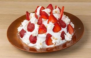 Strawberry cake on the plate and wooden background photo