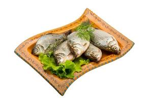 Crucian fish on the plate and white background photo