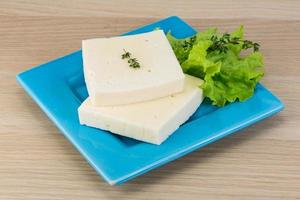 Yellow cheddar on the plate and wooden background photo