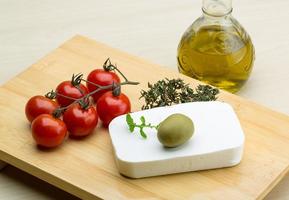 Feta cheese on wooden board and wooden background photo