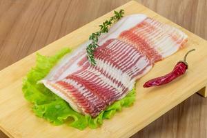 Bacon on wooden board and wooden background photo