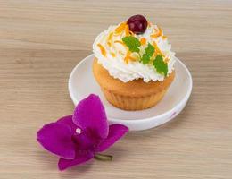 cupcake en el plato y fondo de madera foto