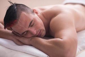 hombre guapo descansando en un centro de masajes spa foto