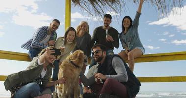 grupo de amigos divirtiéndose el día de otoño en la playa foto