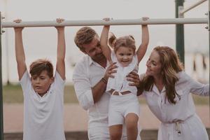 pareja mayor en ropa casual con sus hijos pasando tiempo en el parque de vacaciones juntos. tiempo familiar . enfoque selectivo foto